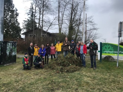 Treekeepers standing by (and on) a large pile of ivy that had been removed from the forest. 
